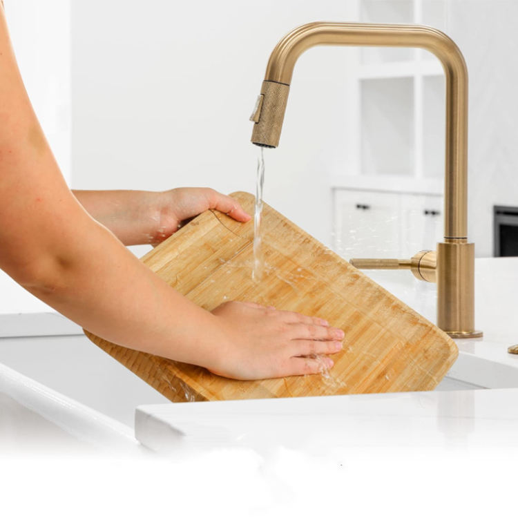 A cheese board made of bamboo, with knives and forks inside.