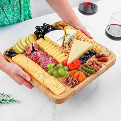 A cheese board made of bamboo, with knives and forks inside.